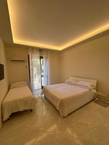 a bedroom with two beds and a window at Dream on the Blue House in Valderice