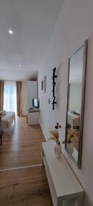 a white living room with a mirror and a table at Matea Apartments Milna in Milna