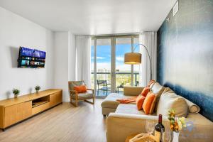 a living room with a couch and a tv at Beachwalk Condo in Hallandale Beach