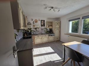 a kitchen with a counter and a table in it at Ferienwohnung Waldbach in Arrach +10 photos