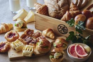 a table topped with bread and pastries and a cutting board at Hakodate Hotel Banso in Hakodate