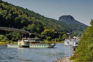 two boats on a river next to a bridge at Haus Falkensteinblick in Rathmannsdorf