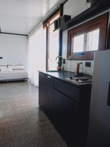a kitchen with a black counter top and a bed at Serena - Tini Houses - in Mar de las Pampas +14 photos