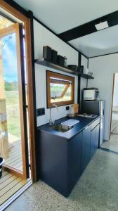 a kitchen with a sink and a counter with a window at Serena - Tini Houses - in Mar de las Pampas