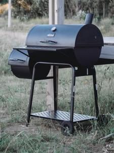 a grill sitting on a stand in the grass at Serena - Tini Houses - in Mar de las Pampas