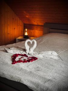 a bed with two towels in the shape of hearts at Maison NidAmour Val-de-Travers in Saint-Sulpice +19 photos