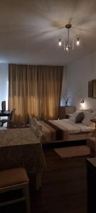 a bedroom with two beds and a chandelier at Matea Apartments Milna in Milna