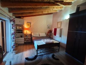 a small bedroom with a bed and a refrigerator at Vila Topalli in Pogradec