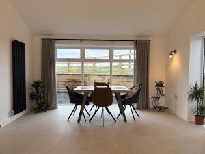 a dining room with a table and chairs and a window at The Farm House in Skipton
