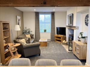 a living room with a couch and a television at The Farm House in Skipton