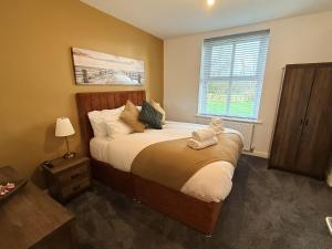 a bedroom with a bed with a stuffed animal on it at The Farm House in Skipton