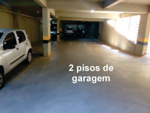 a parking garage with two cars parked in it at Flats da Júnia 110 - funcional com ar, garagem, tv, microondas, frigobar e 14 km aeroporto in Lagoa Santa