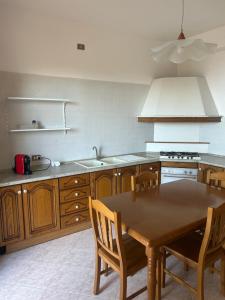 a kitchen with a wooden table with chairs and a sink at Dream on the Blue House in Valderice