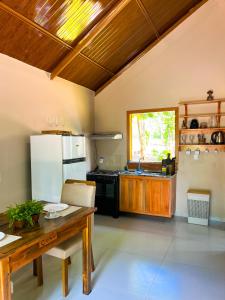 a kitchen with a wooden table and a refrigerator at Bosque dos Buritis in Araguaína