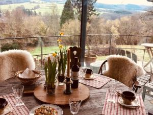 a wooden table with a bottle of wine and flowers on it at Slow Refuge in Fanzel