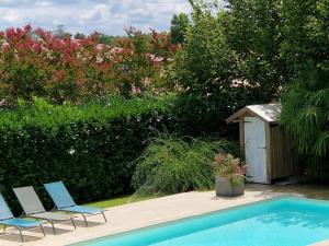 zwei Stühle und ein Swimmingpool neben einem Garten in der Unterkunft Arsuzon in Josse