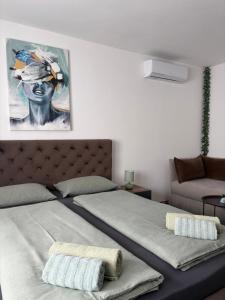 a bedroom with a bed and a painting on the wall at Prenoćište Šimić in Slavonski Brod