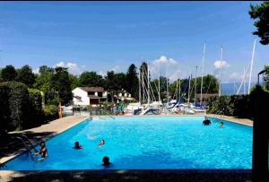 a group of people in a swimming pool with boats at La Mouette de Ripaille in Thonon-les-Bains