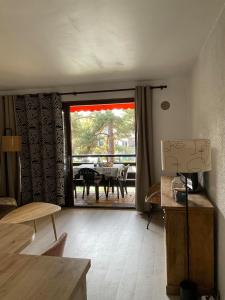 a living room with a large sliding glass door with a table at La Mouette de Ripaille in Thonon-les-Bains