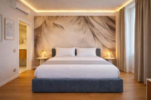 a bedroom with a large bed with a painting on the wall at Royal Suite Apartment in Trieste