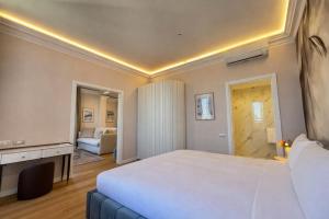 a bedroom with a large white bed and a fireplace at Royal Suite Apartment in Trieste +23 photos
