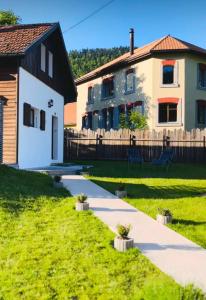 a house and a yard with a walkway at Maison NidAmour Val-de-Travers in Saint-Sulpice