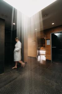 a woman walking through a hallway in a building at Strasserwirt - Ansitz zu Tirol in Strassen