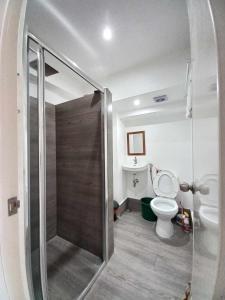 a bathroom with a shower with a toilet and a sink at Tanza Cavite Staycation Condo Loft in Tanza +14 photos