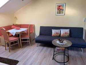 a living room with a blue couch and a table at Ferienwohnungen Kasparbauer in Regen