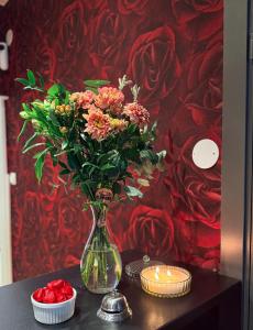 a vase of flowers on a table with candles at Kungsbacken Hotell & Konferens in Katrineholm
