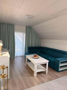 a living room with a blue couch and a table at Apartament Paula SPA Niechorze in Niechorze