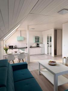 a living room with a blue couch and a table at Apartament Paula SPA Niechorze in Niechorze