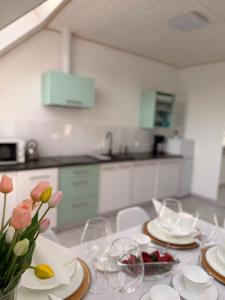 a kitchen with a table with plates and flowers on it at Apartament Paula SPA Niechorze in Niechorze