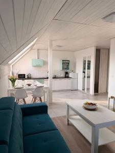 a living room with a blue couch and a table at Apartament Paula SPA Niechorze in Niechorze