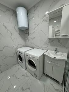 a white bathroom with a washing machine and a sink at Apartman Iva in Foča