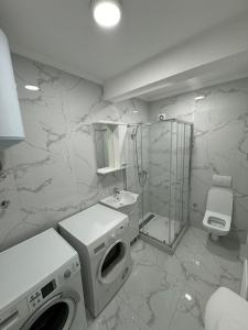 a bathroom with a shower and a washing machine at Apartman Iva in Foča