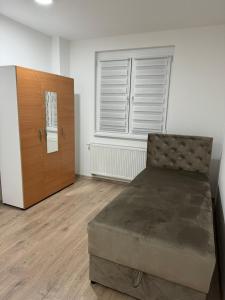a bedroom with a bed and a wooden cabinet at Apartman Iva in Foča