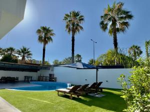 a backyard with palm trees and a swimming pool at Villa Alvor in Alvor