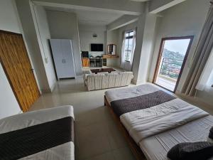 a large room with two beds and a kitchen at Seasons Hotel in Lunglei