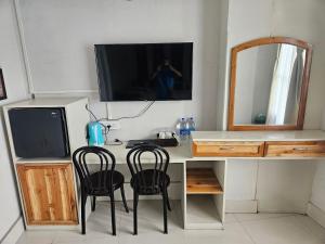 a desk with two chairs and a tv and a mirror at Seasons Hotel in Lunglei