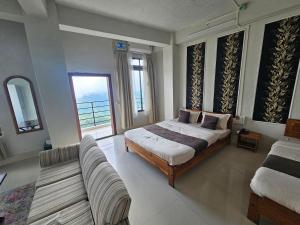 a large bedroom with a bed and a couch at Seasons Hotel in Lunglei