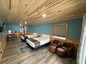 a bedroom with two beds and a couch and a chair at Cass Lake Lodge in Cass Lake