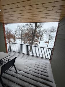 a room with a balcony with snow on the stairs at Cass Lake Lodge in Cass Lake