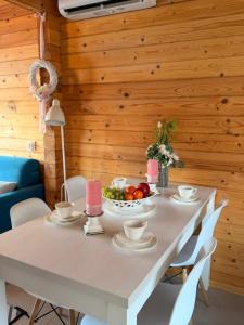 a white table with a bowl of fruit on it at Białe Domki Paula SPA Niechorze in Niechorze