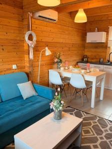 a living room with a blue couch and a table at Białe Domki Paula SPA Niechorze in Niechorze