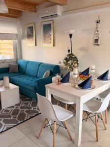 a living room with a blue couch and a table and chairs at Białe Domki Paula SPA Niechorze in Niechorze