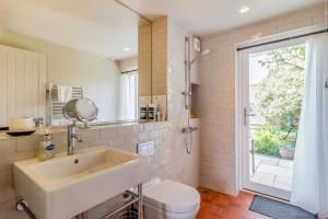a bathroom with a sink and a toilet and a window at 6 Bed in Walberswick oc-vin in Walberswick +22 photos