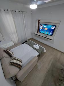 a bedroom with a large bed and a flat screen tv at Casa próx ABC shopping, Pet Friendly in Santo André