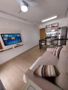 a living room with a couch and a flat screen tv at Casa próx ABC shopping, Pet Friendly in Santo André