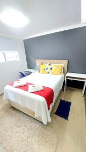 a bedroom with a large bed with a red blanket at Casa próx ABC shopping, Pet Friendly in Santo André